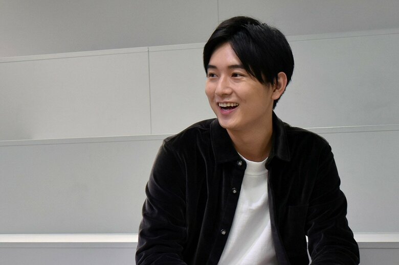 撮影中、たまたま話しかけてきた同僚と話す原田さんはリラックスした表情