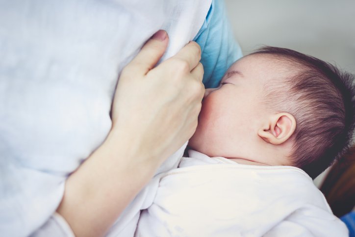 Closeup portrait of mother breastfeeding her newborn baby with breast milk. Drinking milk for good health. Concept about the growth of children. Vintage tone.