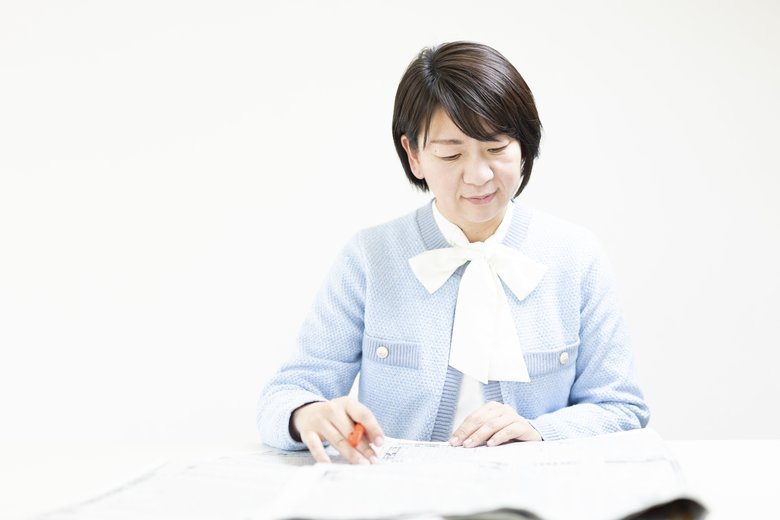 赤ペンを手に競馬欄をチェックする赤見さん