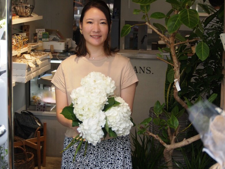 店頭で花を持つ福寿さん