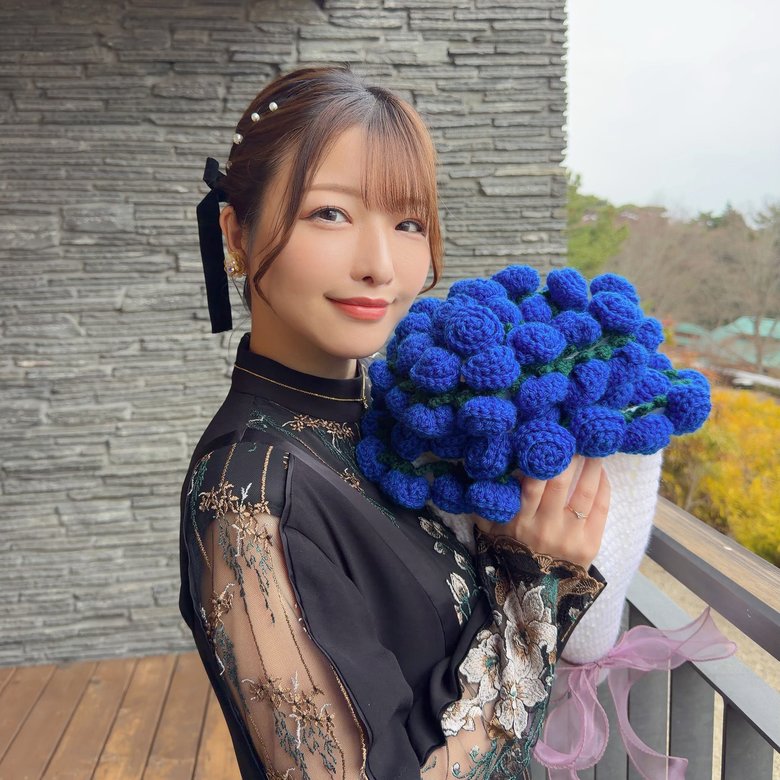 お母さんお手製の花束のブランケットを抱えて幸せそう