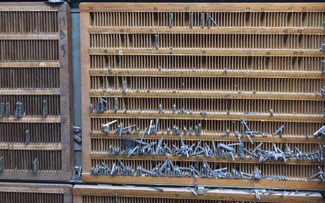 大阪北部地震直後の様子。半数以上が崩落した中でも棚にとどまった活字たち（山添提供）