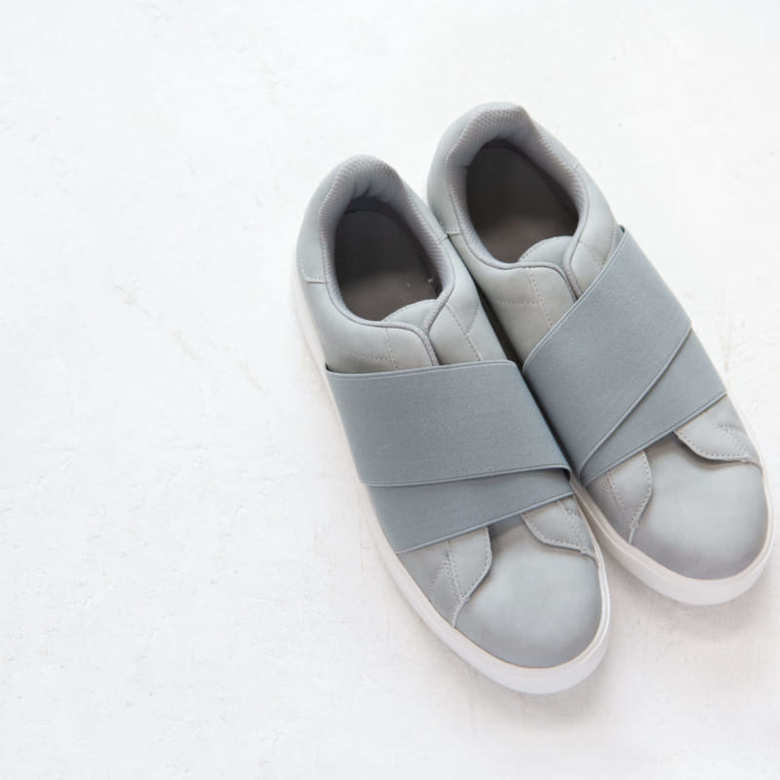 「GU」のメンズのスニーカー。シンプルなデザインの中にクロスしたラバーバンドが光る、洗練された一足。「レースタイプよりもカジュアル見えし過ぎないデザインが大人のカジュアルスタイルを牽引してくれます」（山本さん）

