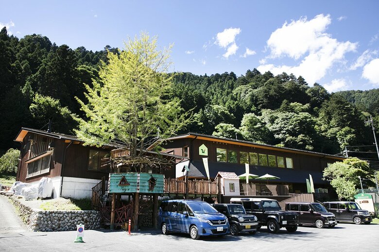 青い空と新緑に囲まれた東京チェンソーズのオフィス（写真左側の建物）