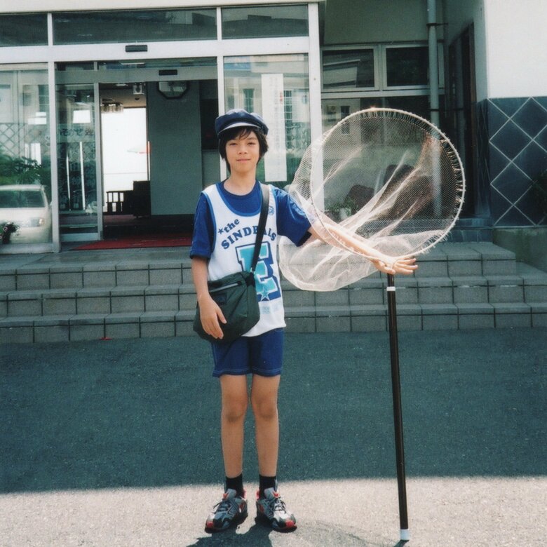 身長と同じくらいの大きなタモ網を持つ小学5年生のころの鈴木香里武さん