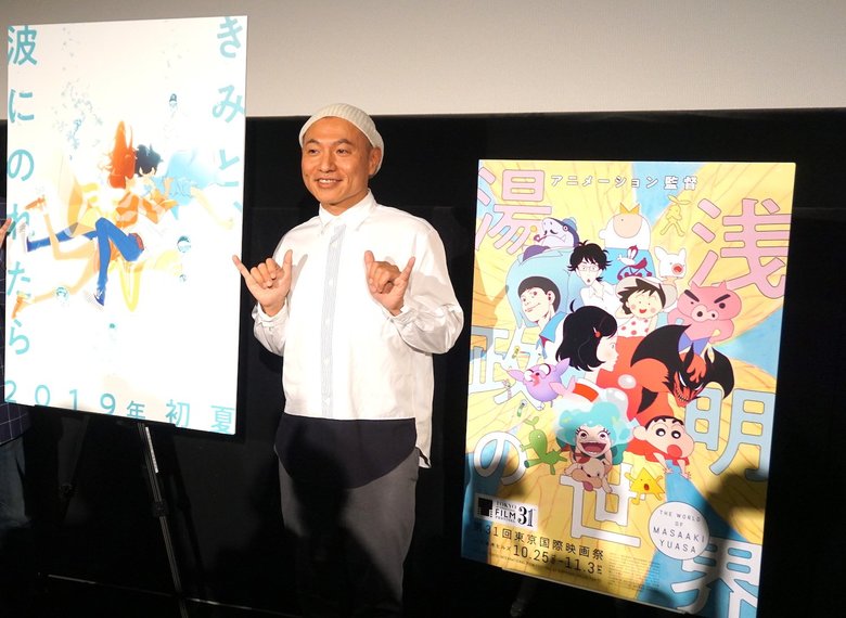 サーファーのあいさつ”シャカサイン”でポーズを決める湯浅監督