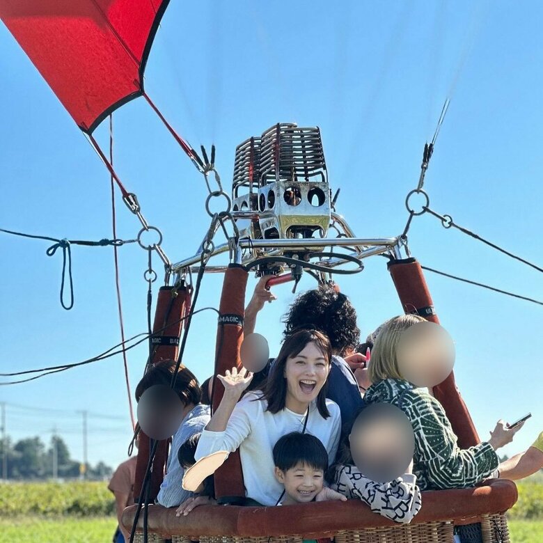気球に乗って満面のスマイルを見せる蛯原英里さんと息子さん