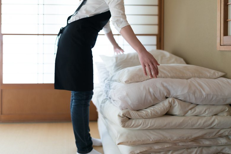 ふとんを畳んでいるイメージ