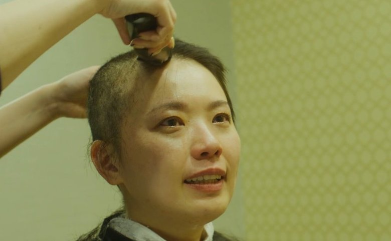 坊主頭にする徳留さん。頬には一筋の涙が