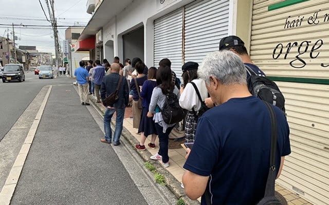 午前9時半から配布される整理券を求めて多くの人々が列をつくる