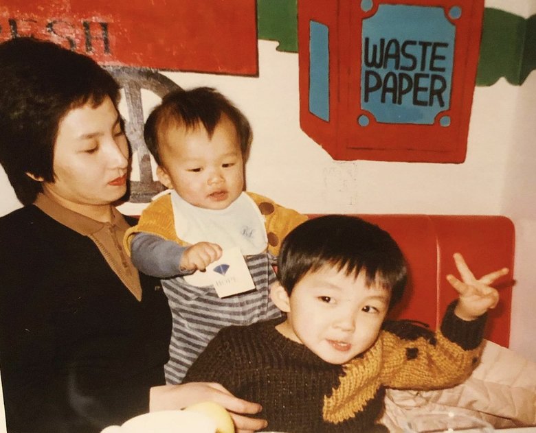 両親が離婚前。ピースをする河井さん、母と弟と。