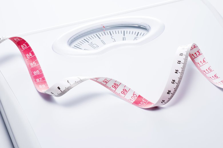 Close-up of a tape measure and Bathroom scale