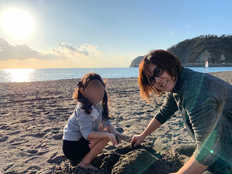 次女と逗子の海岸で砂遊びをするリラックスムードの石本さん