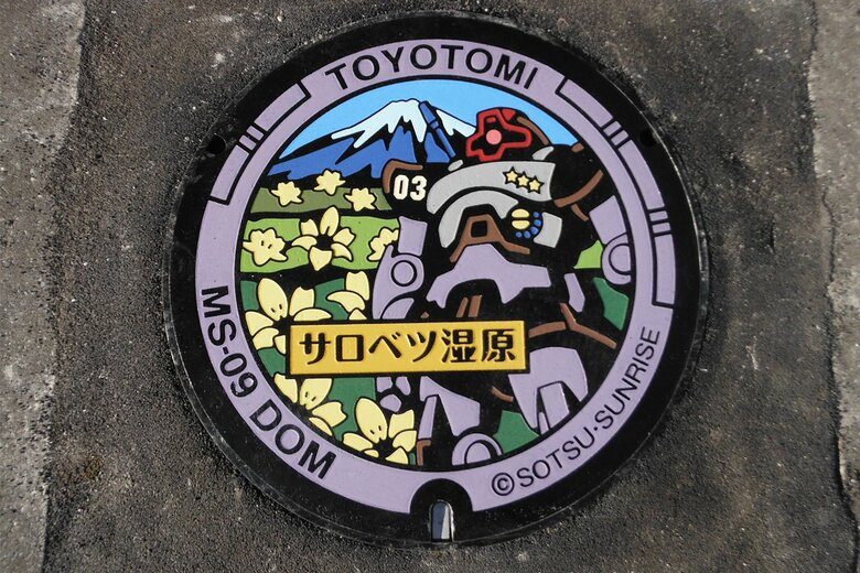 北海道/豊富町　総合交流施設「湯の杜ぽっけ」（北海道天塩郡豊富町字温泉）に設置されたドムマンホール(c)創通・サンライズ