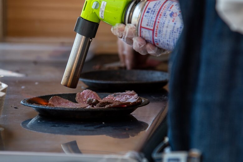 提供前にはよりおいしくなるよう低温加熱した肉をバーナーであぶるこだわり