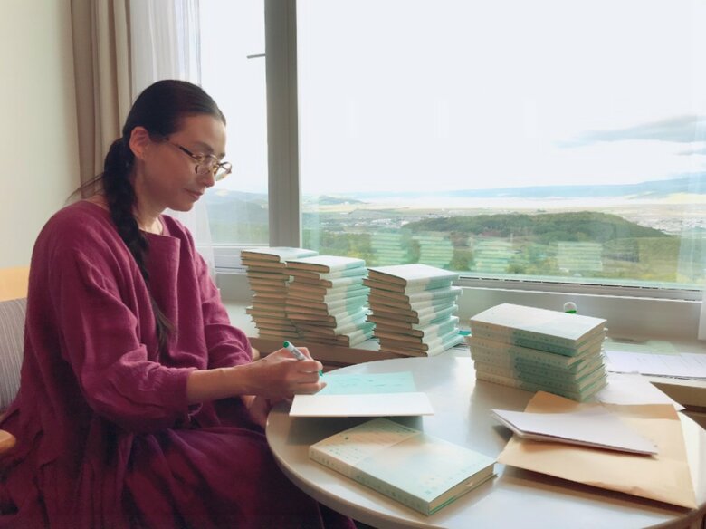 2021年、富良野にて自作エッセイ『めざめの森をめぐる言葉』のサインを書く「尊敬する作家・小川洋子さんがあとがきを寄せてくれました」