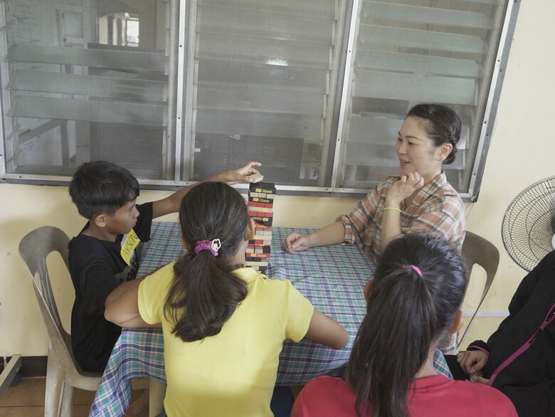 フィリピンの児童養護施設の子どもたちとゲームをする玉城千春さん　協力／認定NPO法人CFFジャパン　