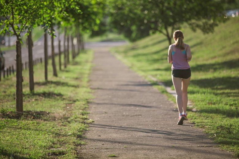 自然の中でジョギングを行う女性の画像