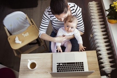 39031398 - young mother in home office with computer and her daugher