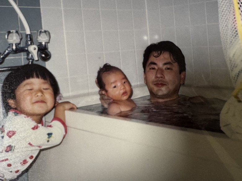 赤ちゃんのころの赤木さん。お父さんと入浴中