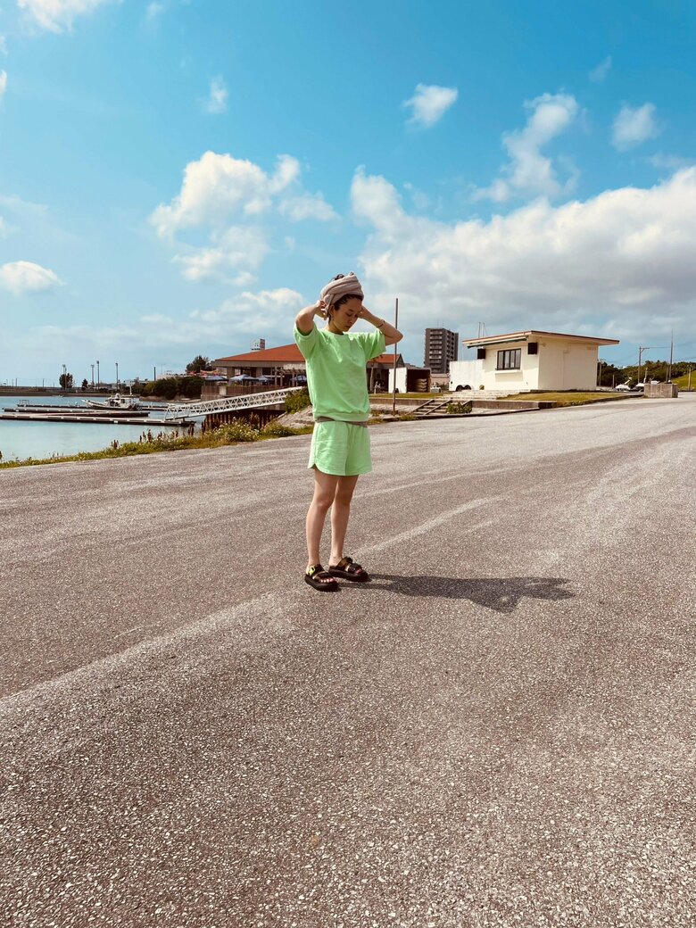 青空に映えるグリーンのセットアップ姿で佇む島袋さん。すごく健康的！
