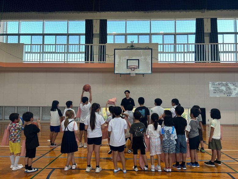 「S.U future」の活動での内尾さん（中央奥）。子どもたちとバスケを楽しみ、プレゼントの手渡しも
