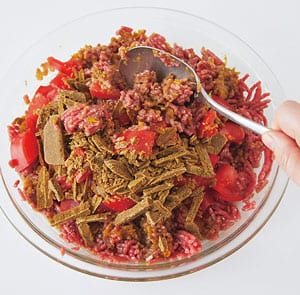 直径25㎝の耐熱皿にひき肉を入れ、Aを加えて、スプーンなどでよく混ぜる。2㎝角に切ったトマト、粗く刻んだカレールウを加えて、さらに混ぜ合わせる。