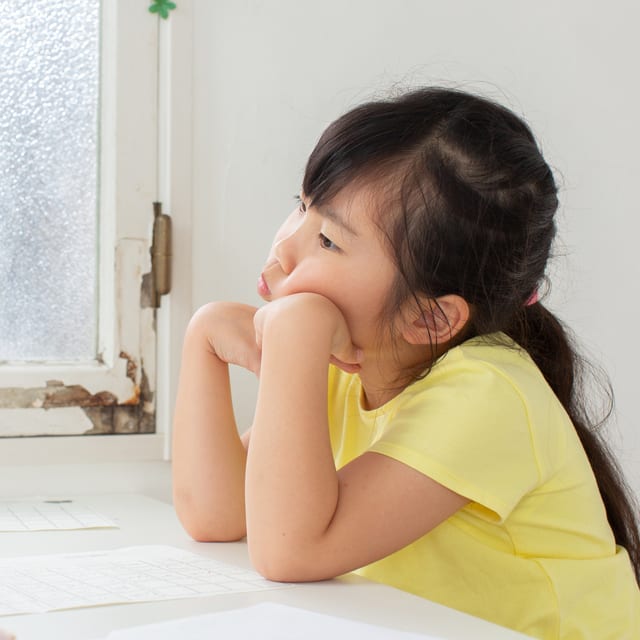 悩む少女のイメージ（PIXTA)