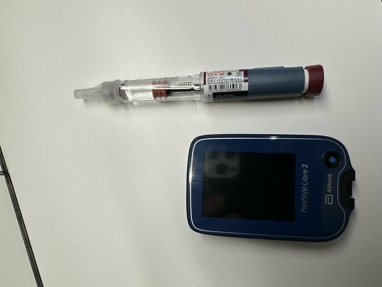 コージーさんの命を支えるインスリン注射と腕に取りつけて血糖値を計測する「リブレ」