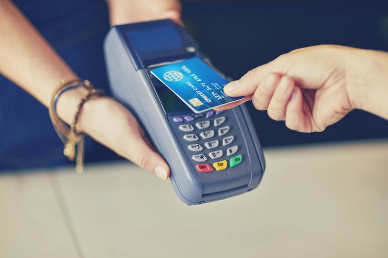 Customer making contactless payment through credit card in coffee shop