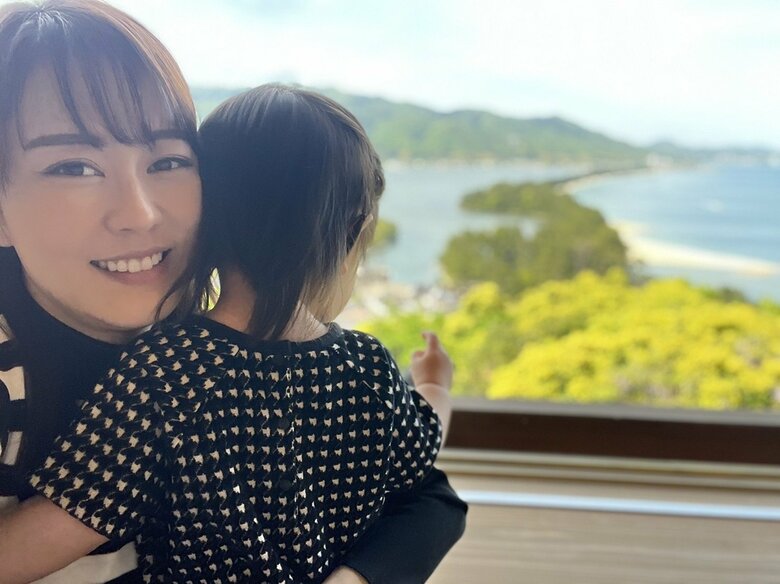 1歳の娘さんを抱っこしながら優しいママの表情を見せる丘さん