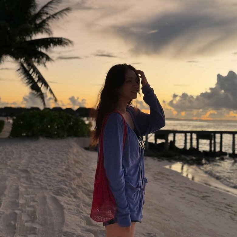 家族で訪れたモルディブのビーチで美しい夕日を眺める野波さん