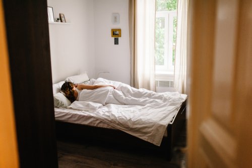 不倫相手とベッドで寝そべる妻の画像