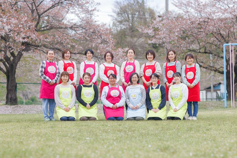 桜が美しく咲き誇る春、NPO法人まんまるママいわての仲間たちと佐藤さん（前列左から3番目）