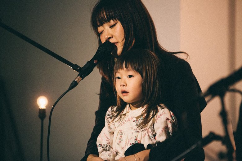 ひざに長女の「なまこちゃん」を乗せて歌う坂本美雨さん。愛おしそう…