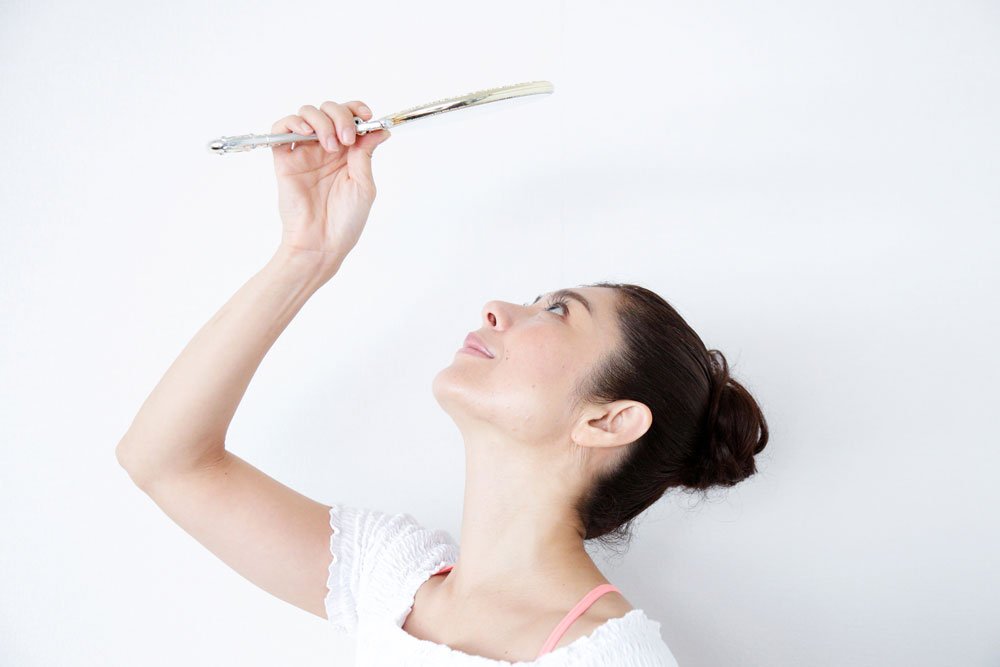 上むきに手鏡を見上げる間々田佳子