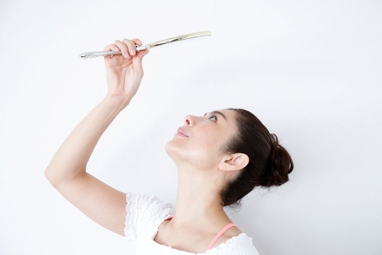 上むきに手鏡を見上げる間々田佳子