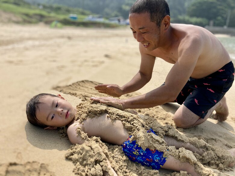 サラサラな砂に埋まる長男くんと夫で詩人の桑原滝弥さん