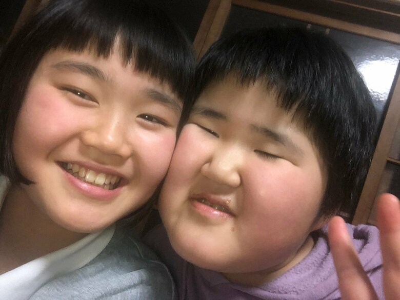 顔を寄せ合い笑顔で自撮りをするここなさん（左）と知的障がいを伴う重度自閉スペクトラム症児のゆいなさん（右）