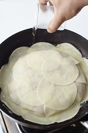 フライパンを弱めの中火にかけ、熱くなってきたら鍋肌から水を注ぐ。ふたをして8〜9分ほど蒸し焼きにする。