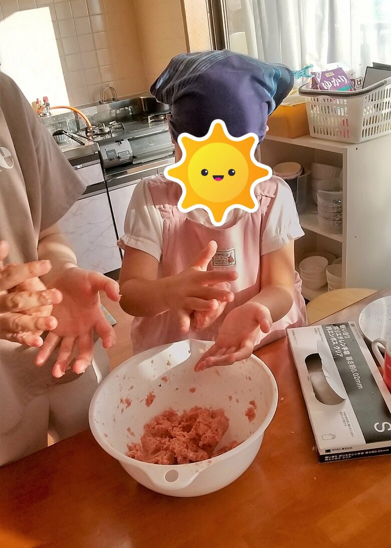 職員と一緒にハンバーグ作り。担当した子（写真右）は「みんなが美味しく食べてくれて嬉しい」と話していたとか