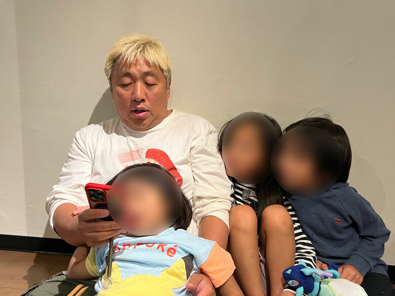 ゲームを楽しみながら家族団らんする旦那さんとお子さんたち