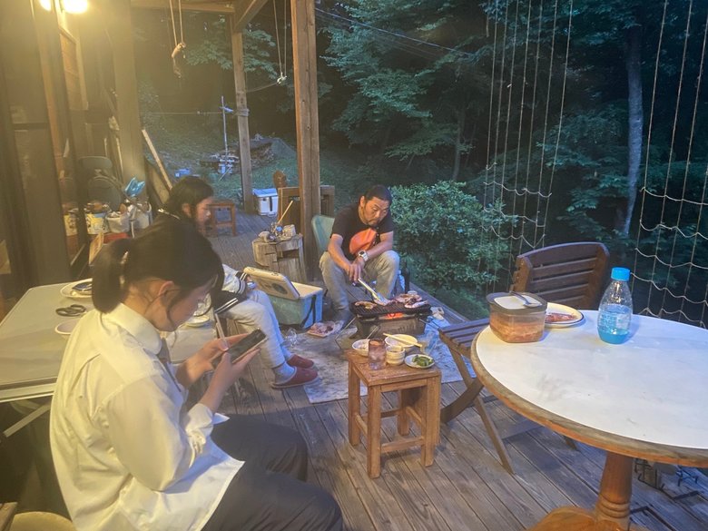 ウッドデッキで食事をすることも。釣ってきたイカを娘たちに焼く父