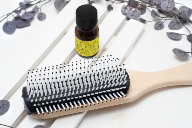 髪の毛と頭皮をブラッシングするブラシとオイルの画像