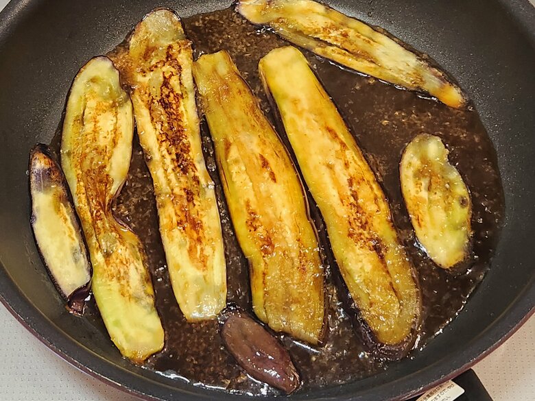 【作り方2】フライパンにごま油を適量引いてなすを炒める。焼き目がついたら弱火にして調味料を投入し全体になじませる