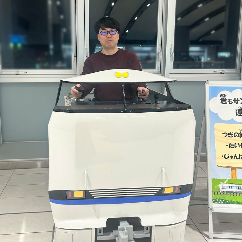 笑顔で遊具の電車に乗る太田さん、以前はこの笑顔がなかなか見られなかった