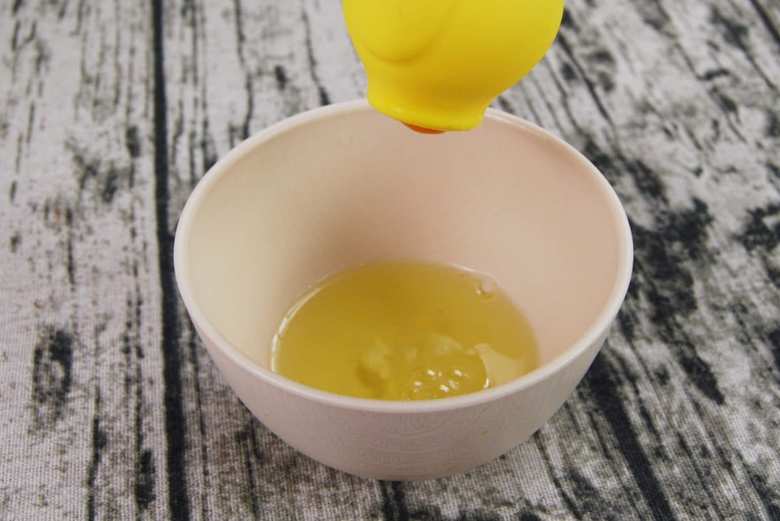 持ち上げると、たまごの黄身がお尻から少し顔を覗かせています。白身が多少混入してしまっても、そのまま持っていれば流れ落ちていくので心配は不要。産卵中のような見た目のニワトリを別の容器に移動して、黄身をとり出しましょう。