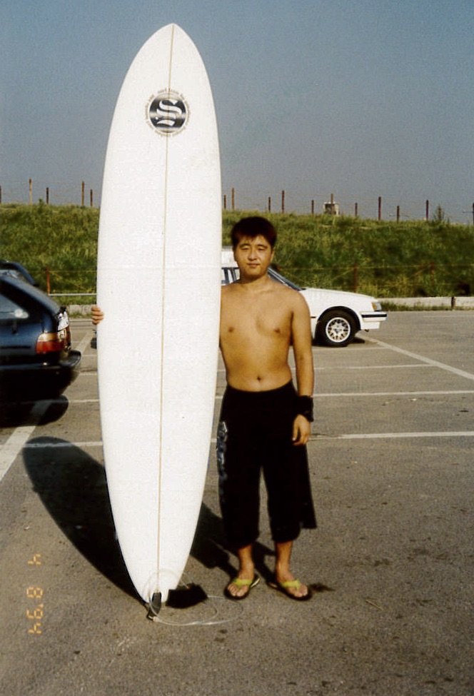 サーフィンにはまっていた21歳のころ。今よりずいぶんスリムな小力さん
