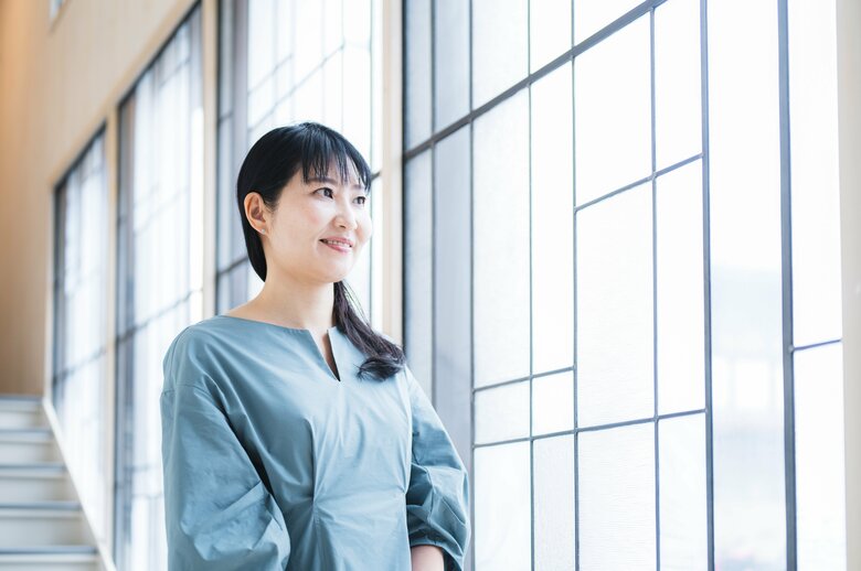 保育園運営の統括をする野上さん。光が差し込むドイツ製のステンドグラスの前で