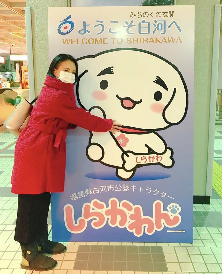 移住先の福島県白河市の公認キャラクター「しらかわん」と記念撮影する田村さん